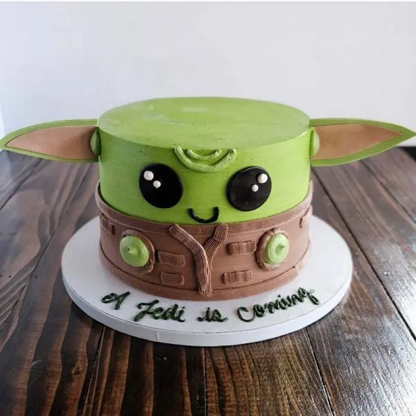 A cake that is shaped like the head of an adorable baby yoda.