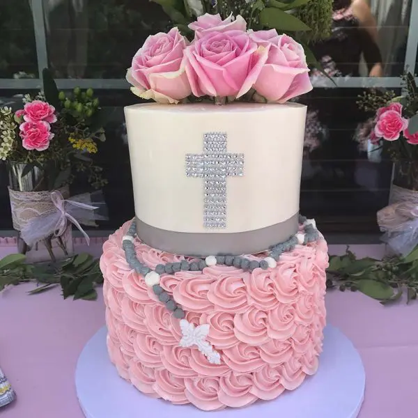 A pink and white cake with flowers on top