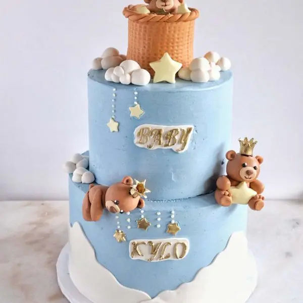 A blue and white cake with bears on top of it