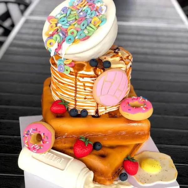 A cake that is made to look like pancakes and donuts.