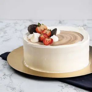 A cake with white frosting and strawberries on top.