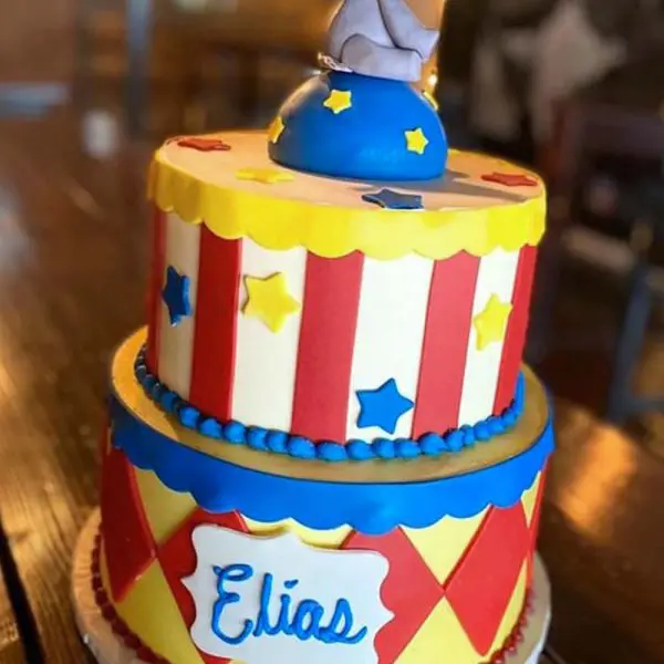 A circus themed cake with a name on top.