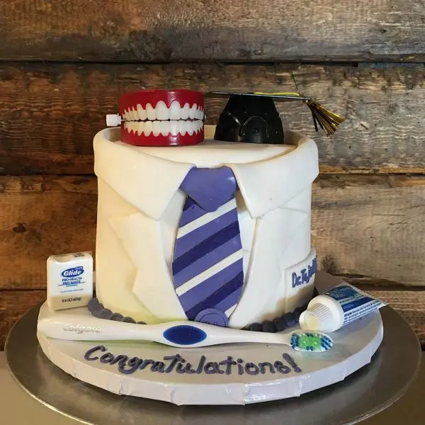 A cake with a tie and tooth paste on it.