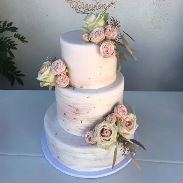 A three layer cake with flowers on top of it.