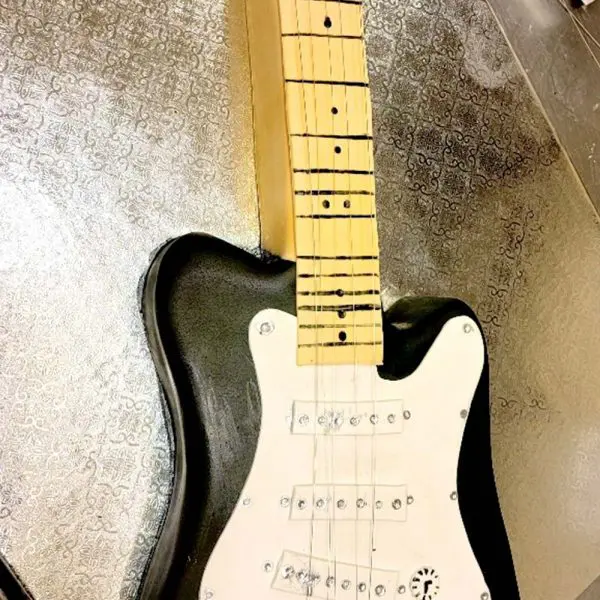 A black and white guitar sitting on top of the floor.