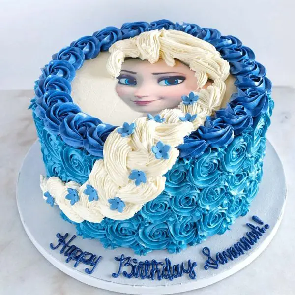 A blue and white cake with a picture of elsa