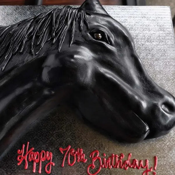 A black horse head cake with red lettering