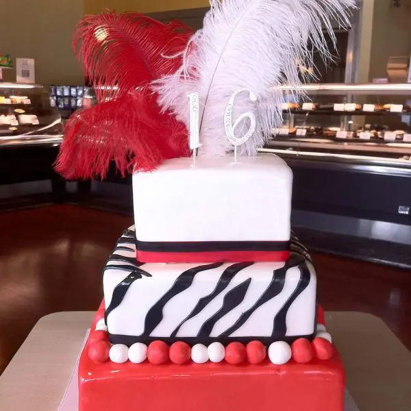 A cake with red, white and black designs on it.