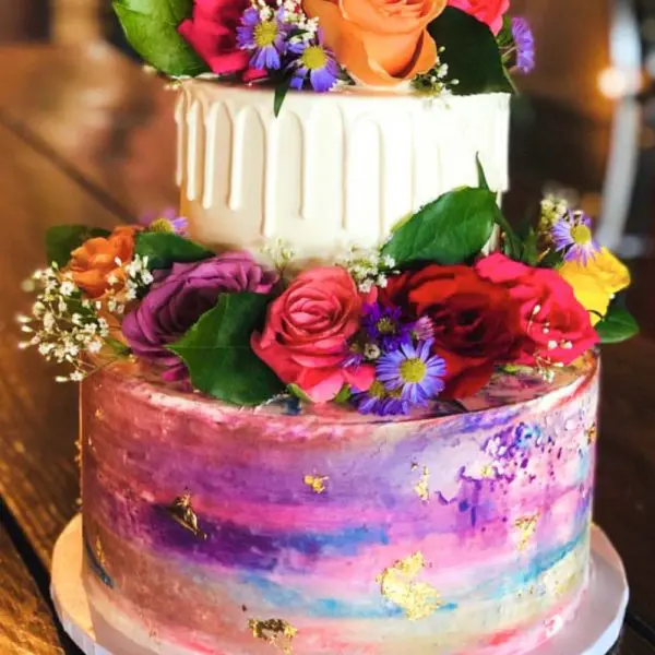 A two layer cake with flowers on top of it.