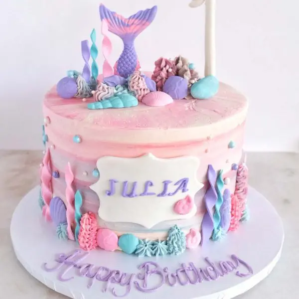 A birthday cake with pink and purple decorations.