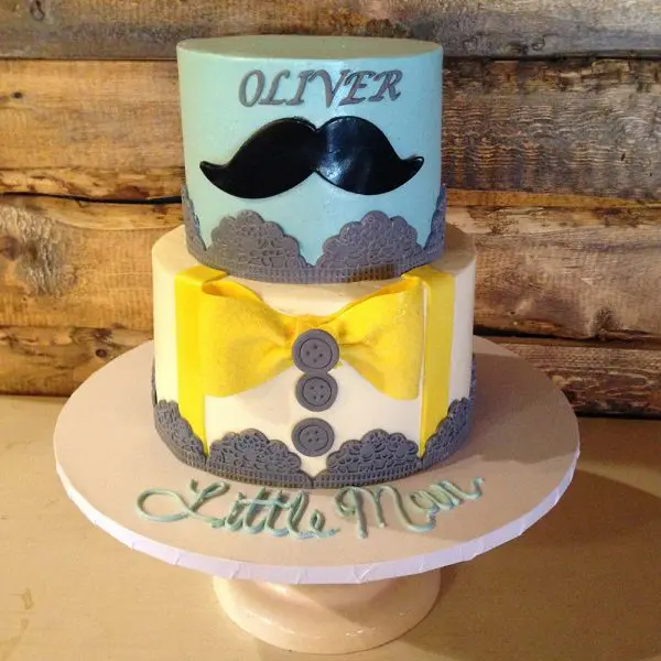 A cake with a bow tie and mustache on top of it.