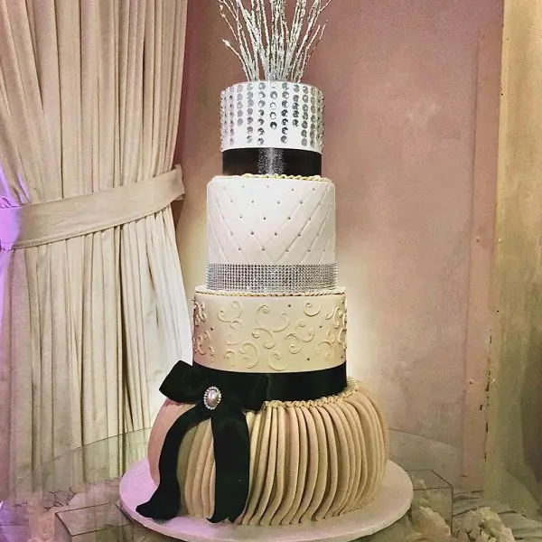 A wedding cake with silver and black decorations.