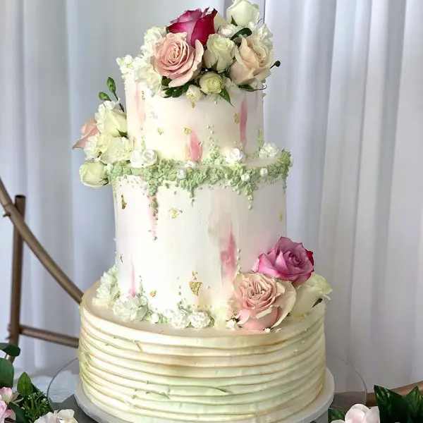 A three tiered cake with flowers on top of it.