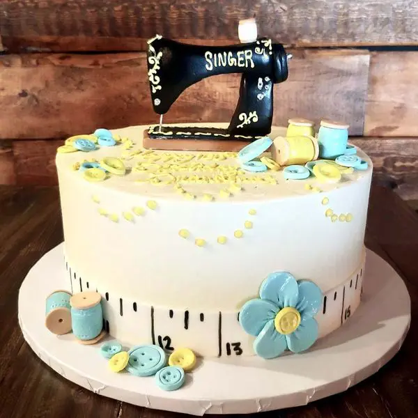 A cake with sewing themed decorations on top of it.