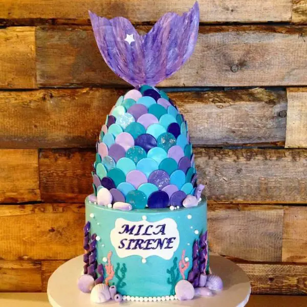 A cake with a mermaid tail on top of it.