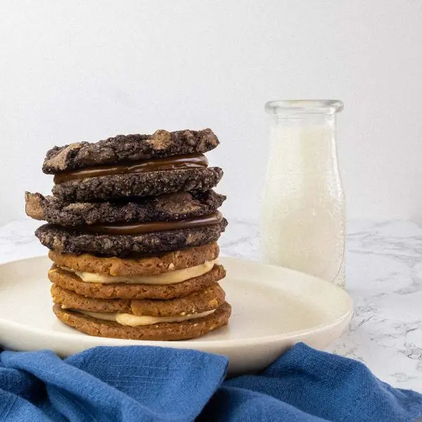 A plate with several different cookies stacked on top of each other.