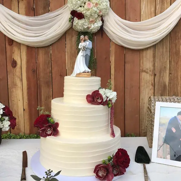 A wedding cake with flowers on top of it.