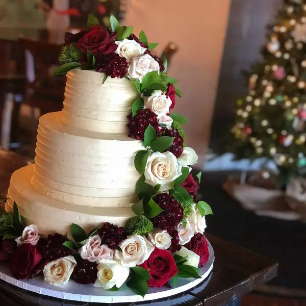 A three layer cake with roses on it