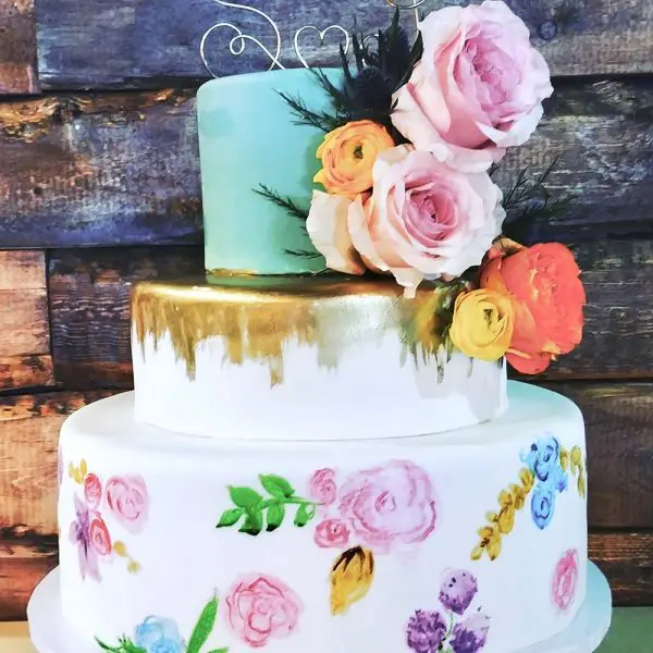 A three tiered cake with flowers on top of it.