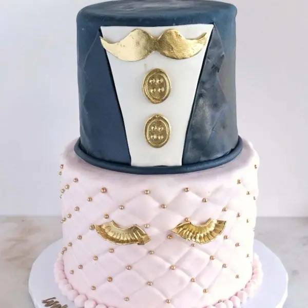 A cake with two layers and a top layer decorated in gold.