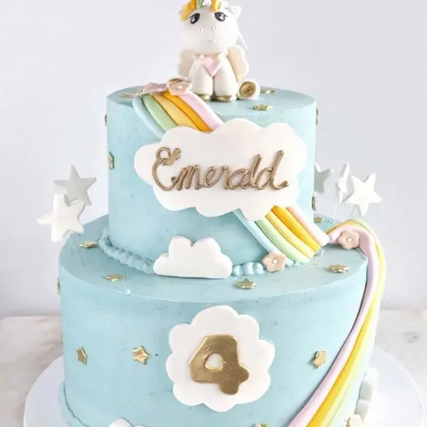 A blue cake with stars and clouds on top of it.