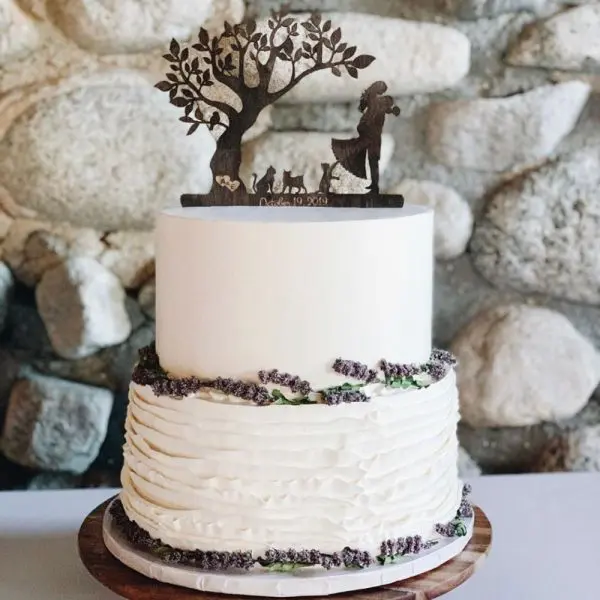 A white cake with a tree and dog on top of it.