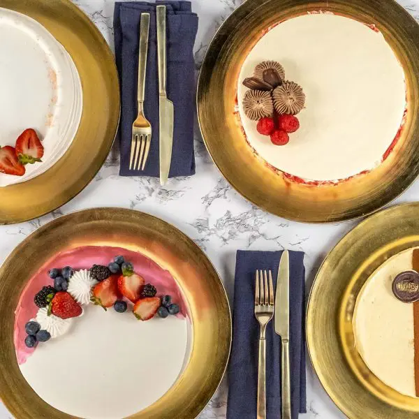 A table with four plates and forks on it