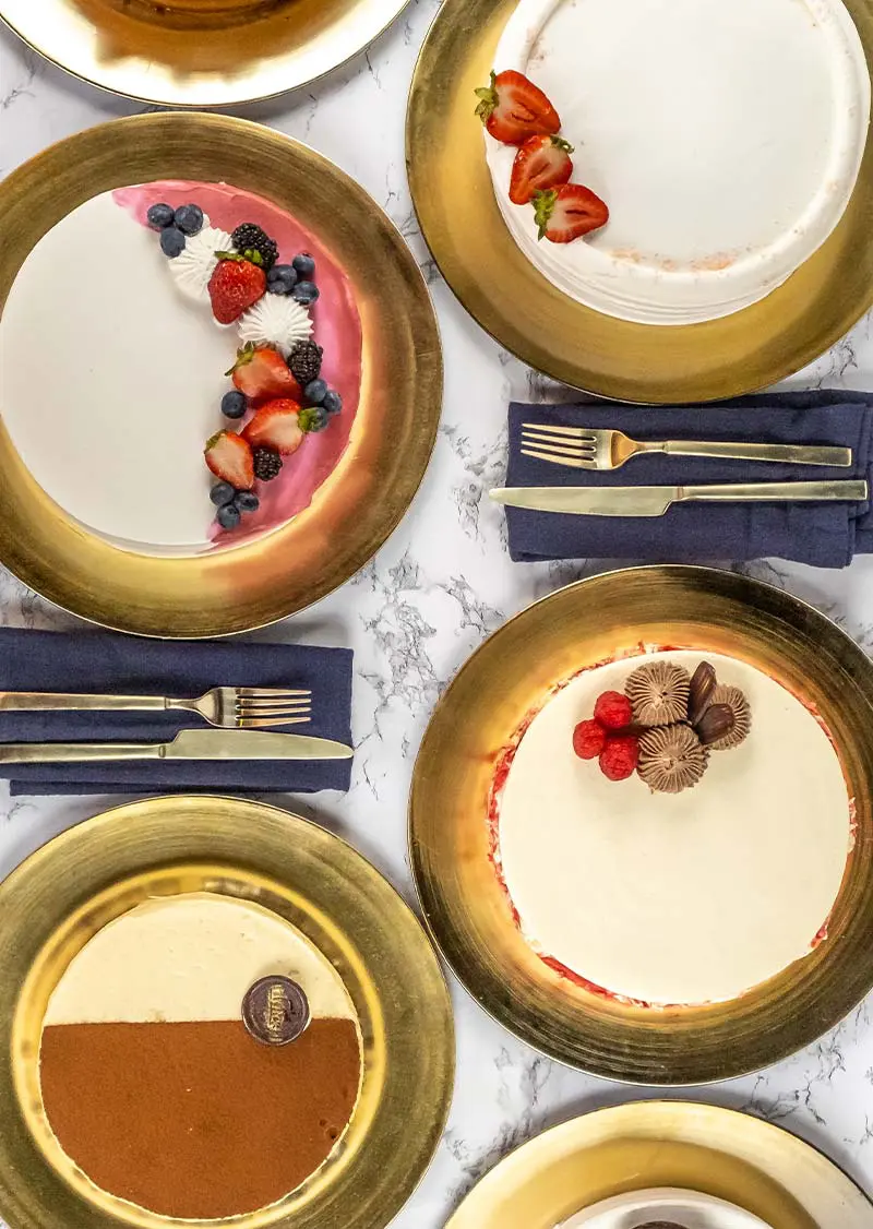 Four plates of different desserts on a table.