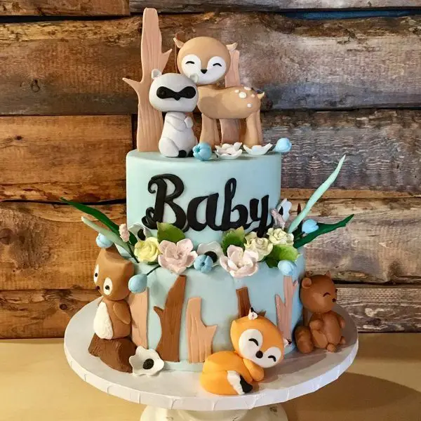 A baby shower cake with animals and flowers